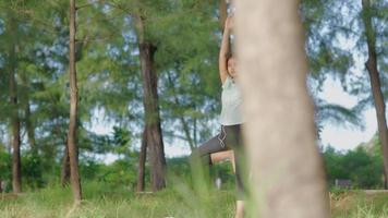 Aziatisch meisje dat 's ochtends yoga doet in de tuin aan het strand video