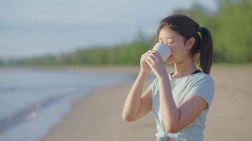 ung kvinna som dricker mjölk på morgonen på stranden video