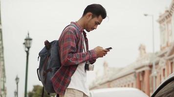 Hombre joven blogger usando un teléfono inteligente durante un viaje video