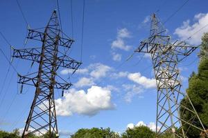 Electric pole against the sky. A high-voltage power line runs through the track. photo