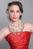Bonita modelo de moda de temática roja con muchas perlas foto