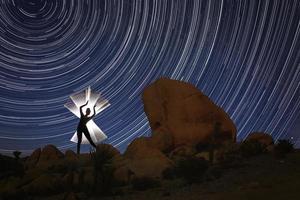 hermosa modelo iluminada con tubo de luz con senderos de la estrella del norte en joshua tree foto