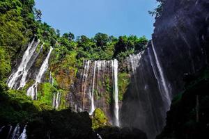 TUMPAK SEWU.Panoramic beautiful deep forest waterfall in Indonesia photo