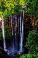 TUMPAK SEWU.Panoramic beautiful deep forest waterfall in Indonesia photo