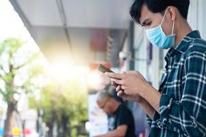 Man wear face mask using mobile smartphone photo