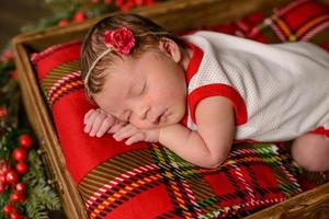 Little newborn girl eight days old in Christmas suit photo