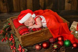 Little newborn girl eight days old in Christmas suit