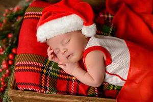 Little newborn girl eight days old in Christmas suit photo