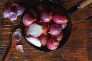 Fresh red onions In the pan on the kitchen table photo