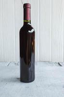 Botellas de vino sobre fondo de madera blanca