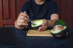 fruta de aguacate en mano lista para comer foto