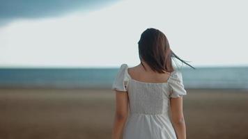 aziatische vrouw die langs het strand loopt video