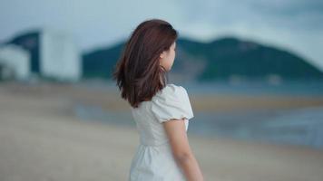 aziatische vrouw die langs het strand loopt video