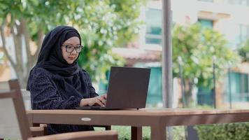 mulheres muçulmanas bonitas sentadas do lado de fora trabalhando de acordo com o slogan formulário de trabalho para casa