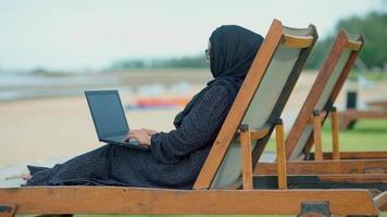 mulheres muçulmanas bonitas sentadas do lado de fora trabalhando de acordo com o slogan formulário de trabalho para casa