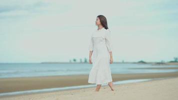 asiatische Frau, die am Strand spazieren geht video