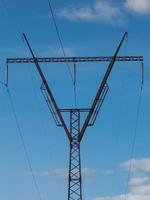 Líneas eléctricas de alta tensión y torres sobre fondo de cielo azul foto