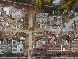 vista aérea de arriba hacia abajo de un sitio de construcción. vista de drone vertical de grúa torre, cimientos y equipos de construcción foto