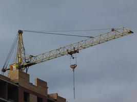 Grúa amarilla en el fondo de un edificio en construcción foto