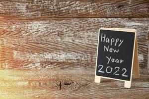Feliz año nuevo 2022 signo de tablero negro de fondo foto