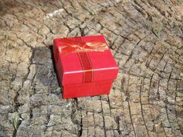 caja de regalo roja se encuentra en el tocón de un árbol foto