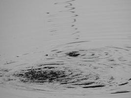 Texture of water in a river, surface in the rain, stains photo