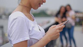 femme asiatique utilisant un smartphone appréciant la lecture des médias sociaux. video