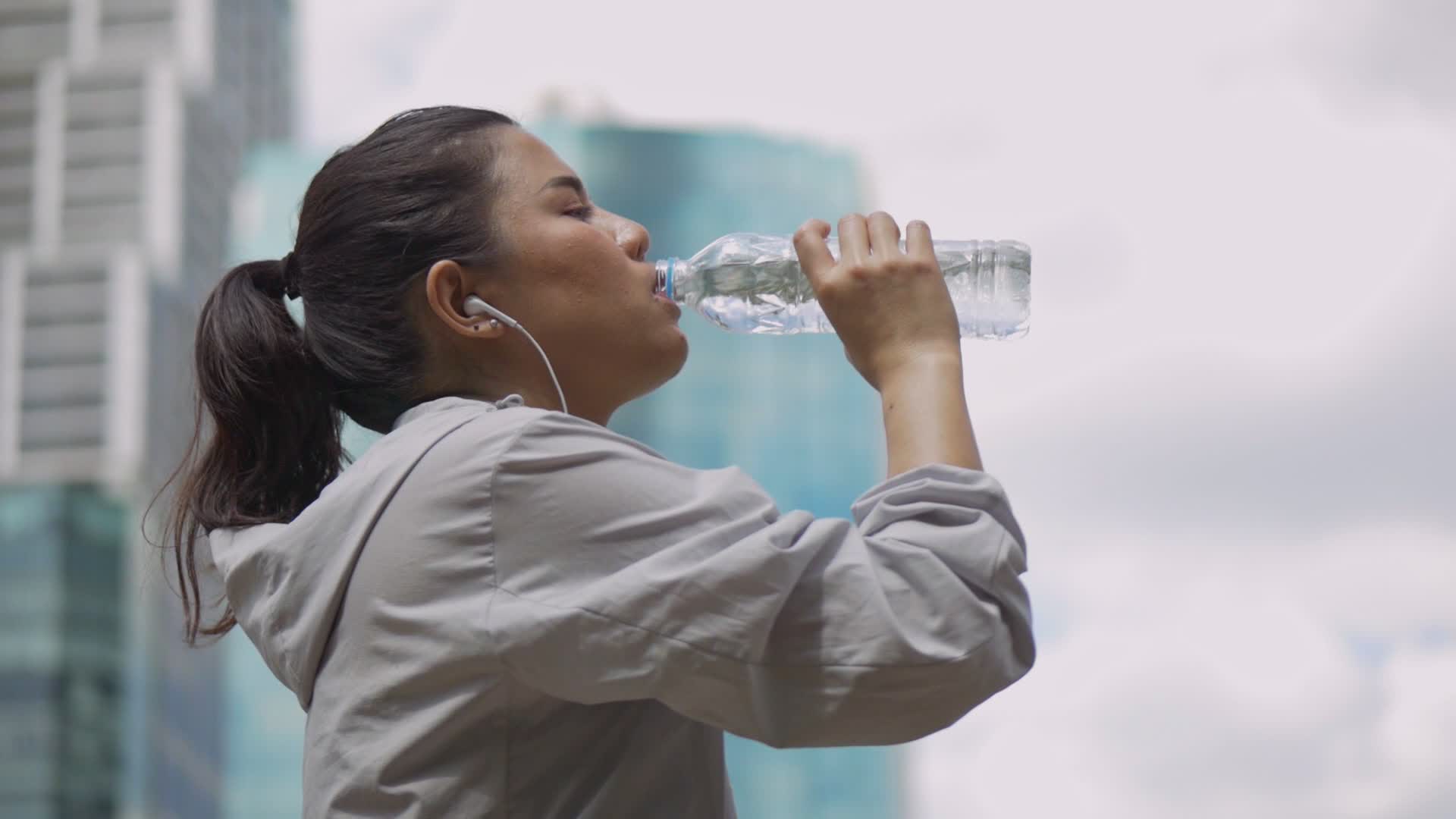 woman drinking water from plastic cup, isolated on a white