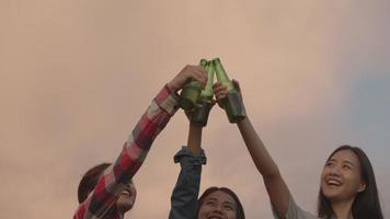 joven mujer asiática adolescente amigos felices acampando en la naturaleza divirtiéndose juntos bebiendo cerveza y tintineando vasos. video