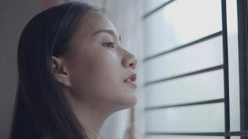 Porträt lächelnde asiatische Frau, die Vorhänge im Zimmer zu Hause öffnet. video