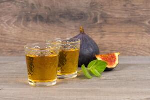 two shot glasses and fresh figs fruits on rustic table