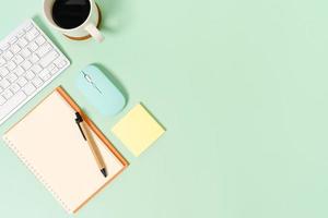 Creative flat lay photo of workspace desk. Top view office desk with keyboard, mouse and open mockup black notebook on pastel green color background. Top view mock up with copy space photography.