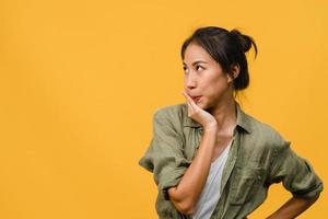 Portrait of young Asia lady with negative expression, excited screaming, crying emotional angry in casual clothing isolated on yellow background with blank copy space. Facial expression concept.