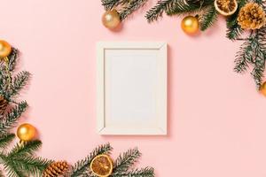 Minimal creative flat lay of winter christmas traditional composition and new year holiday season. Top view mockup black picture frames for text on pink background. Mock up and copy space photography. photo