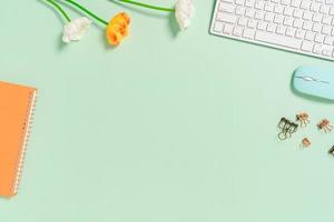 Minimal work space - Creative flat lay photo of workspace desk. Top view office desk with keyboard, mouse and notebook on pastel green color background. Top view with copy space, flat lay photography.