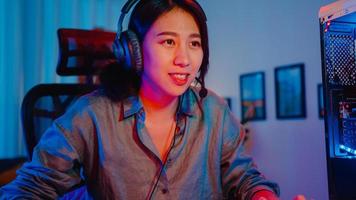 Happy asia girl gamer wear headphone competition play video game online  with smartphone colorful neon lights in living room at home. Esport  streaming game online, Home quarantine activity concept. 3652236 Stock Photo