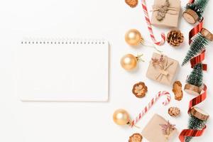 Minimal creative flat lay of winter christmas traditional composition and new year holiday season. Top view open mockup black notebook for text on white background. Mock up and copy space photography. photo