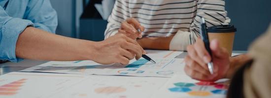 jóvenes empresarios asiáticos reunidos intercambiando ideas sobre nuevas ideas sobre proyectos y socios trabajando juntos planificar la estrategia de éxito disfrutan del trabajo en equipo en la oficina. Fondo de banner panorámico con espacio de copia. foto