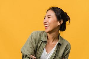 Portrait of young Asia lady with positive expression, smile broadly, dressed in casual clothing over yellow background. Happy adorable glad woman rejoices success. Facial expression concept. photo