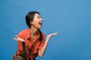 Young Asia lady feel happiness with positive expression, joyful surprise funky, dressed in casual cloth isolated on blue background. Happy adorable glad woman rejoices success. Facial expression. photo