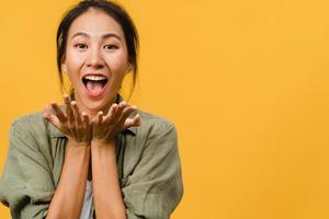 Young Asia lady feel happiness with positive expression, joyful surprise funky, dressed in casual cloth and looking at camera isolated on yellow background. Happy adorable glad woman rejoices success. photo