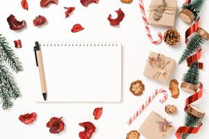 Minimal creative flat lay of winter christmas traditional composition and new year holiday season. Top view open mockup black notebook for text on white background. Mock up and copy space photography. photo