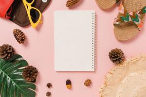 Creative flat lay of travel vacation spring or summer tropical fashion. Top view beach accessories open mockup black notebook for text on pastel background. Top view mock up copy space photography. photo