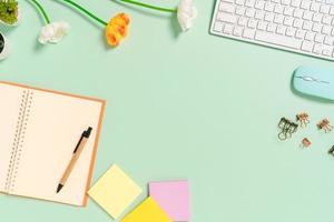 Creative flat lay photo of workspace desk. Top view office desk with keyboard, mouse and open mockup black notebook on pastel green color background. Top view mock up with copy space photography.