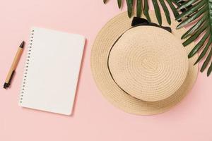 Creative flat lay of travel vacation spring or summer tropical fashion. Top view beach accessories open mockup black notebook for text on pastel background. Top view mock up copy space photography. photo