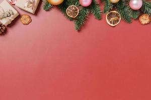 plano creativo mínimo de composición tradicional navideña y temporada navideña de año nuevo. vista superior adornos navideños de invierno sobre fondo rojo con espacio en blanco para el texto. copie la fotografía del espacio.