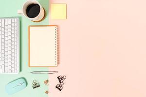 Creative flat lay photo of workspace desk. Top view office desk with keyboard, mouse and open mockup black notebook on pastel green pink color background. Top view mock up with copy space photography.