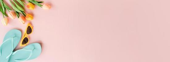 plano creativo de viajes vacaciones primavera o verano moda tropical. Accesorios de playa de vista superior sobre fondo de color rosa pastel. banner panorámico con espacio de copia para texto y área publicitaria.