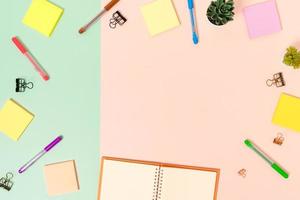 Creative flat lay photo of workspace desk. Top view office desk with keyboard, mouse and open mockup black notebook on pastel green pink color background. Top view mock up with copy space photography.