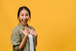 Young Asia lady feel happiness with positive expression, joyful surprise funky, dressed in casual cloth and looking at camera isolated on yellow background. Happy adorable glad woman rejoices success. photo